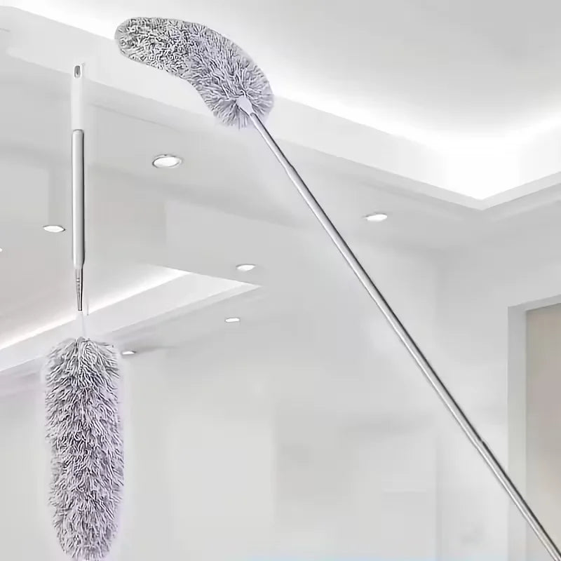 A silver retractable microfiber duster with a fluffy head is suspended from the ceiling in a bright room.