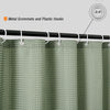 A close-up view of a light green waterproof shower curtain with metal grommets and plastic hooks.