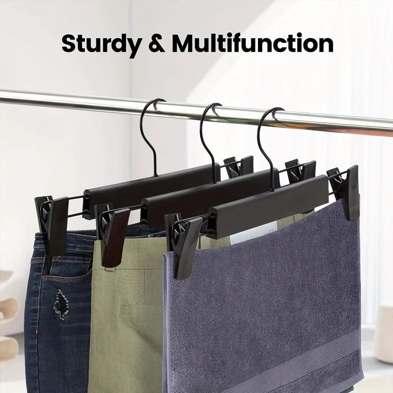 A set of sturdy, multifunction adjustable clothes hangers holding denim jeans and fabric bags.