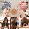 Close-up of a woman wearing a pink microfiber hair drying towel wrap and another woman with long brown hair using the towel.