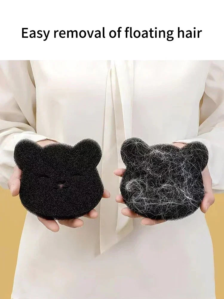 A person is demonstrating the easy removal of floating hair using a black cat-shaped pet hair remover sponge.