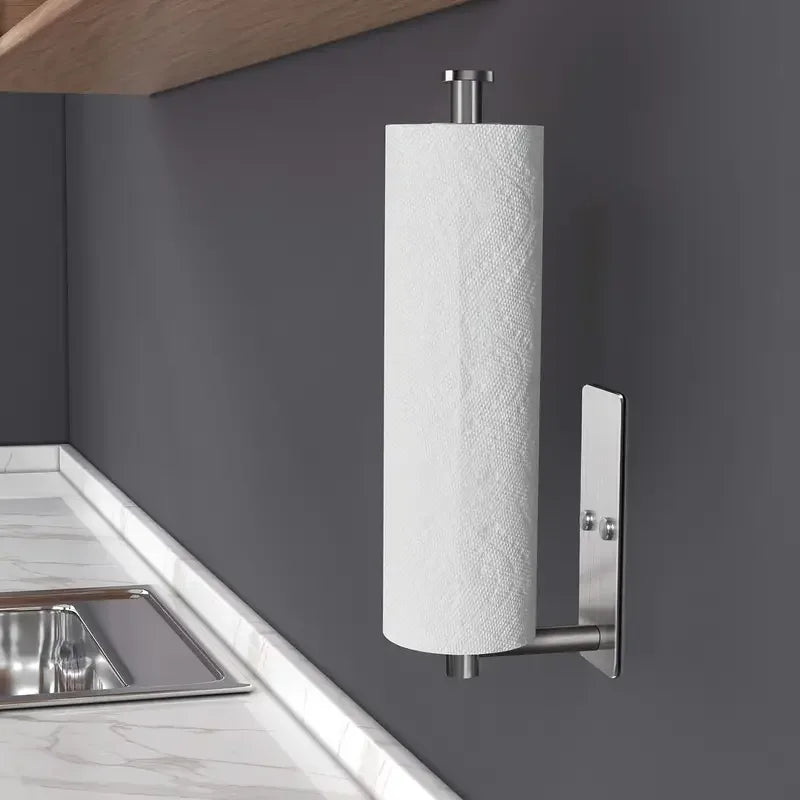 Stainless steel under cabinet paper towel holder mounted on a gray wall above a kitchen sink.