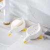 White duck-shaped soap dish with yellow beak sitting on a white bathroom counter.