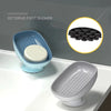 A blue suction cup soap dish with a white soap disc is shown next to a gray ceramic soap dish.