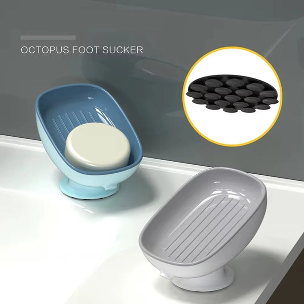 A blue suction cup soap dish with a white soap disc is shown next to a gray ceramic soap dish.