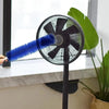 A blue cleaning brush is shown being used on a black electric fan for blind cleaning.