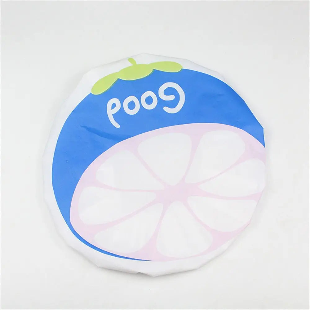 A reusable fruit shower cap featuring a blue background with the word Good and a pink citrus slice design.