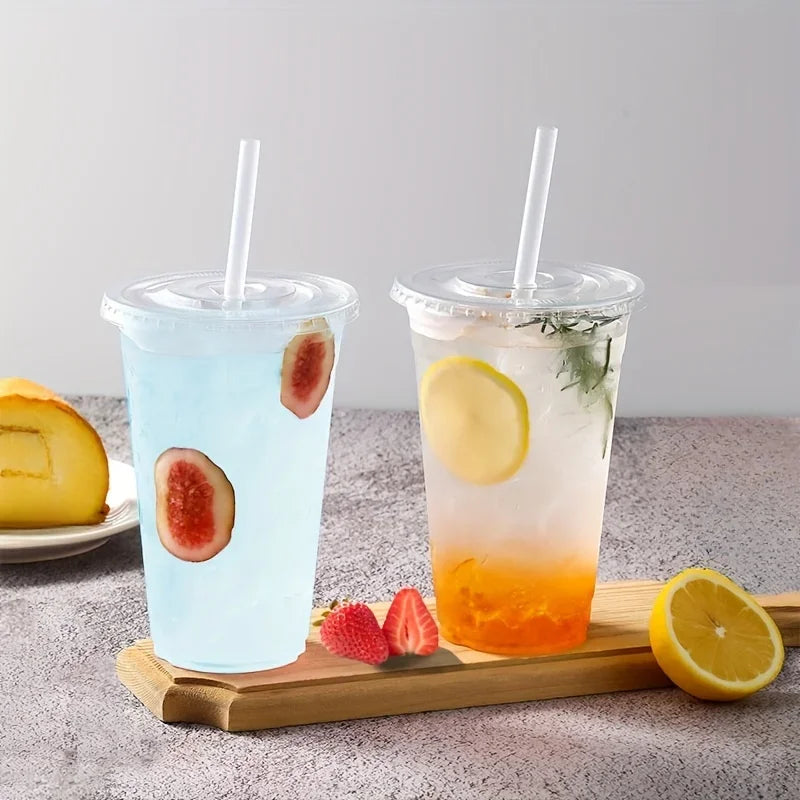 Two clear plastic cups filled with iced beverages, one blue and one orange, garnished with fruit slices and herbs.