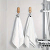 A set of stainless steel clothespins hanging on a white tile, used for laundry and organization.