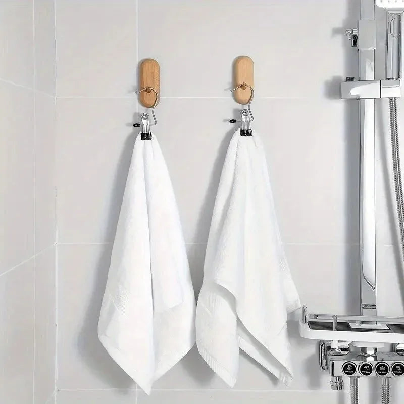 A set of stainless steel clothespins hanging on a white tile, used for laundry and organization.