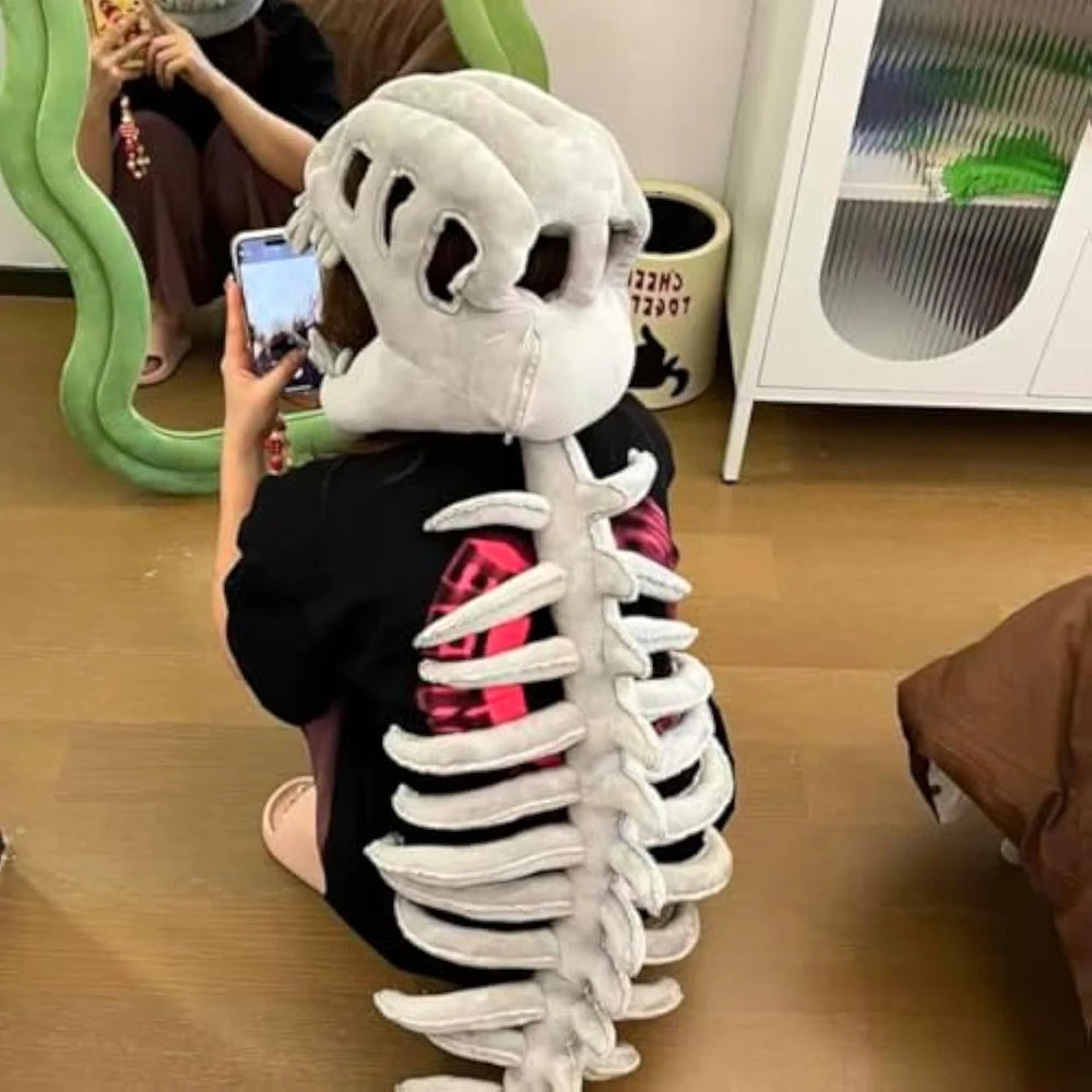 A person is holding a white dinosaur skeleton costume that resembles a rib cage and spine.