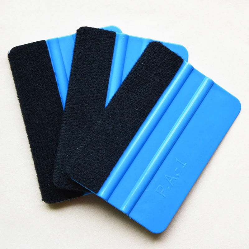 A set of three black suede felt squeegees with blue plastic handles for vinyl wrap and film installation.