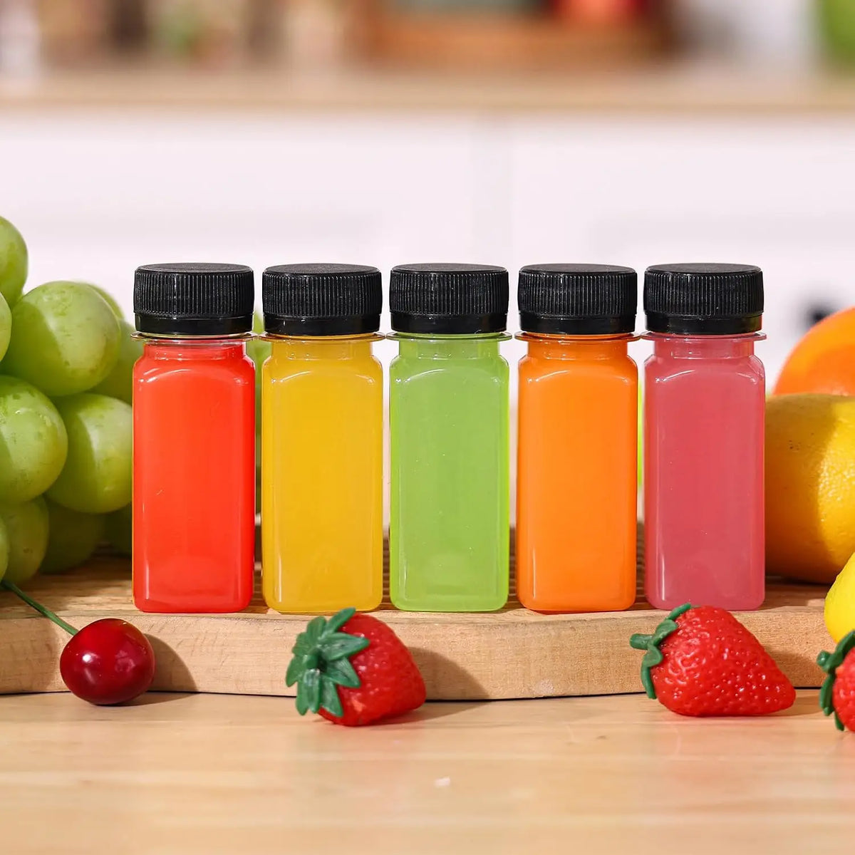 A set of six leak-proof clear juice bottles filled with various fruit juices, arranged on a wooden surface.