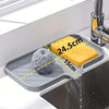 A silicone sink mat organizer holds a yellow sponge, demonstrating its dimensions.