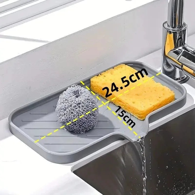 A silicone sink mat organizer holds a yellow sponge, demonstrating its dimensions.