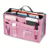 A pink foldable cosmetic organizer pouch with a clear window showing various makeup and personal items.