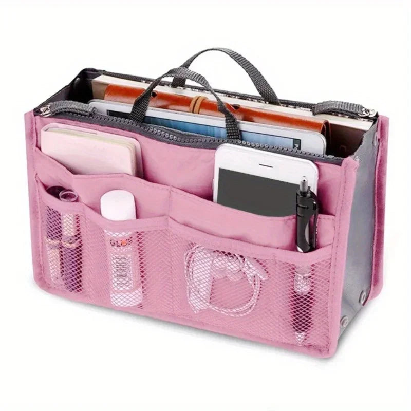 A pink foldable cosmetic organizer pouch with a clear window showing various makeup and personal items.