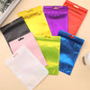 A collection of colorful plastic pouches in various shades including yellow, pink, purple, red, and blue displayed on a light