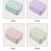 Four ceramic soap dishes with lids in blue, purple, pink, and green colors shown from above.