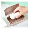 A hand opens a light pink transparent drainage soap dish with a lid, showing the interior.