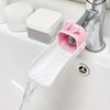 A pink rabbit-shaped faucet extender is shown pouring water from a sink faucet.