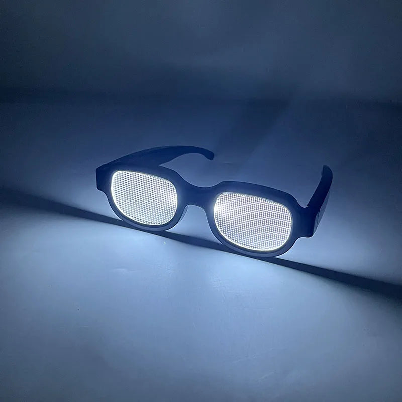 A pair of black LED light up anime glasses resting on a surface, casting a bright glow.