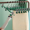 Stainless steel adjustable clothing hangers hanging on a wooden rack