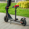 A black electric scooter with an adjustable folding seat and red accents is parked on a paved surface.
