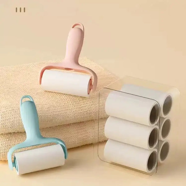 Un rodillo anti-pelusa rosa junto a una pila de toallas beige, con varios rodillos blancos enrollados.