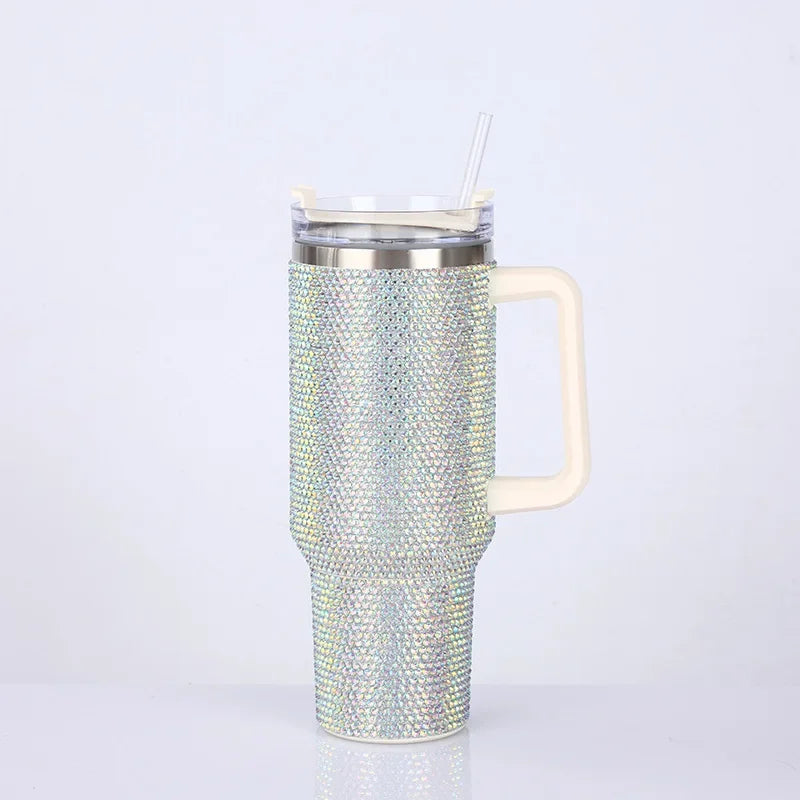Taza aislada de pedrería plateada con tapa transparente y pajita, mostrada sobre fondo blanco.