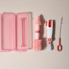 A pink silicone baby bottle cleaning set featuring a bottle brush, cleaning brush, and silicone scissors.