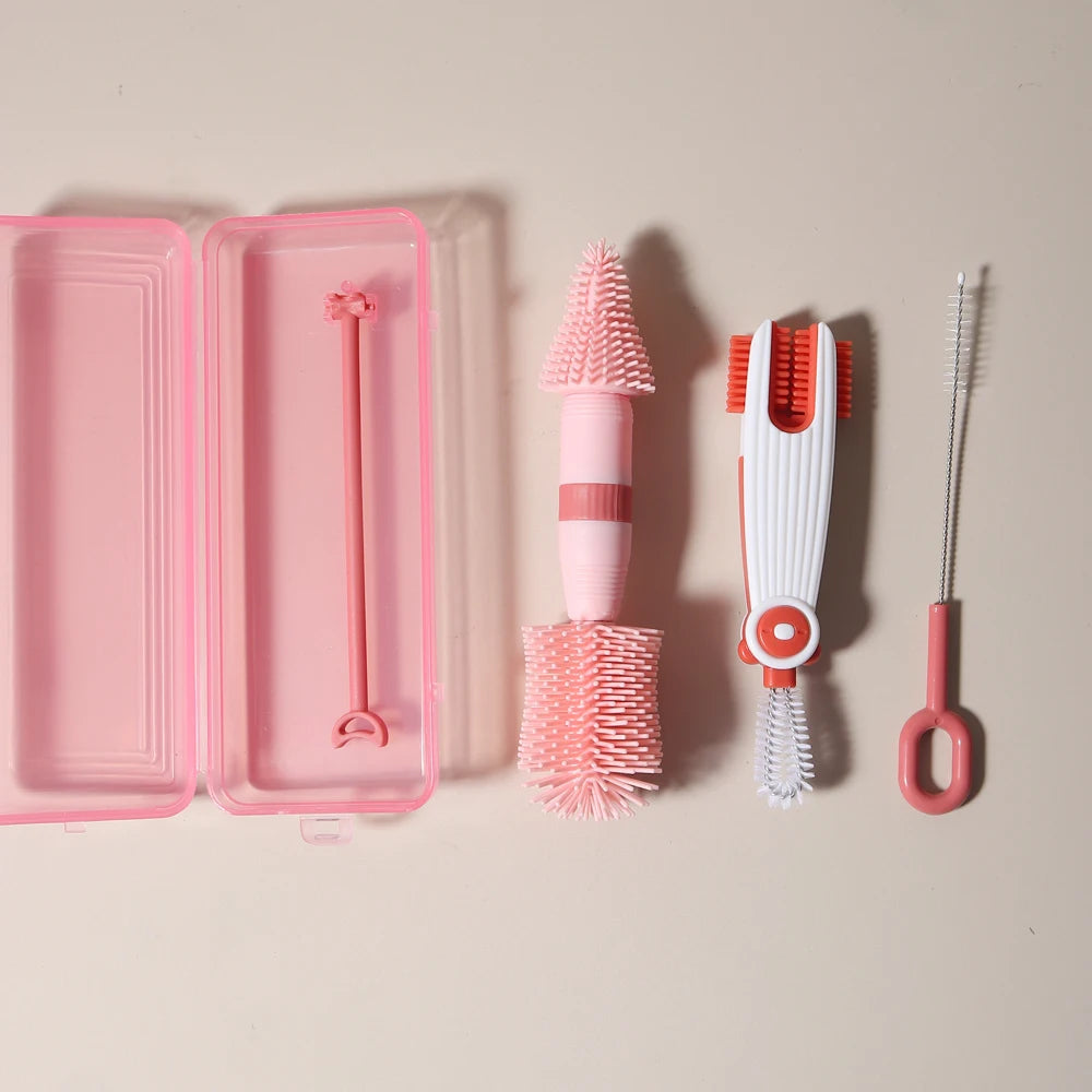 A pink silicone baby bottle cleaning set featuring a bottle brush, cleaning brush, and silicone scissors.
