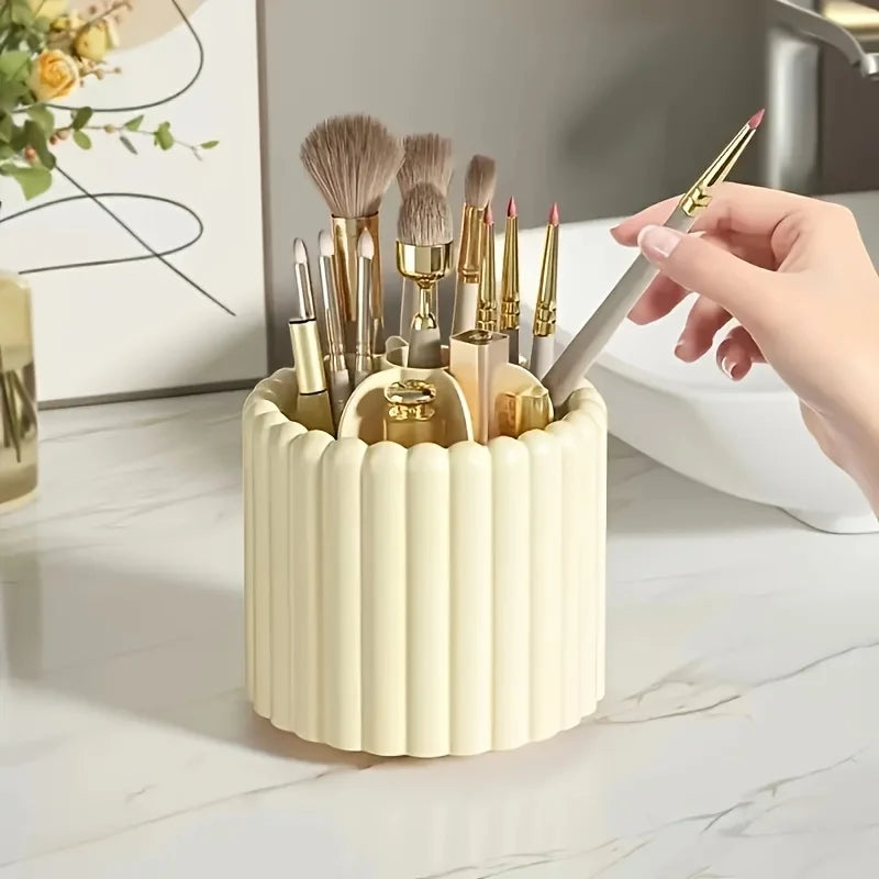 A beige cylindrical organizer holding various makeup brushes and tools on a marble surface.
