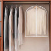 A beige washable clothes hanging dust cover is displayed on a wooden rack.