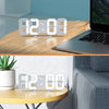 A white 3D LED digital alarm clock displaying the time 82:08:00 resting on a wooden table next to a laptop.