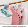 A set of plastic hangers with bow designs for babies aged 0-12, shown hanging on a wooden rod.