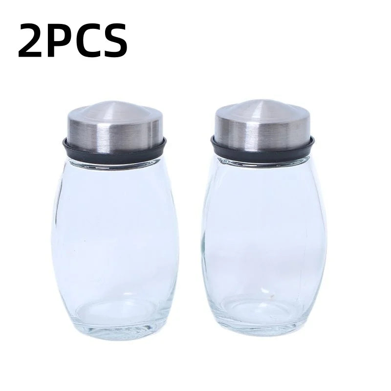 Two clear glass spice jars with stainless steel lids shown side by side.