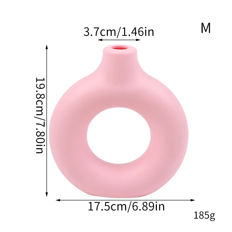 A pink modern round decorative plastic vase with a narrow opening and a smooth, curved body.