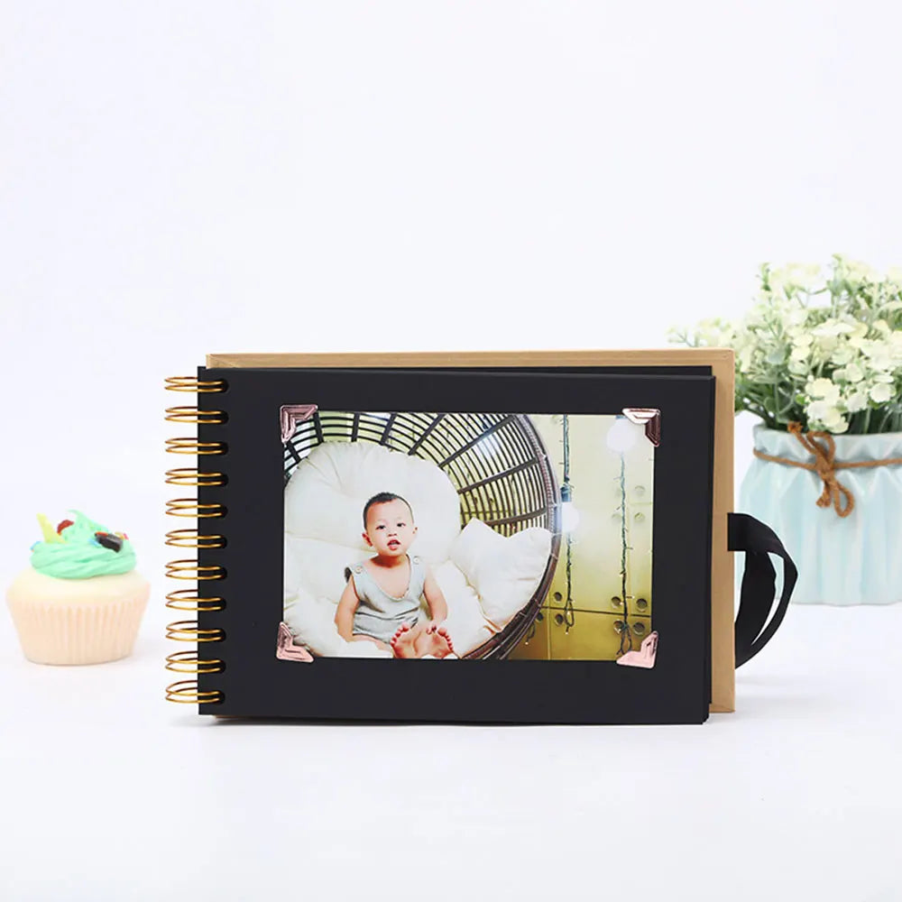 Schwarzes Fotobuchalbum mit goldener Spiralbindung, das ein Baby inmitten von Grün zeigt.