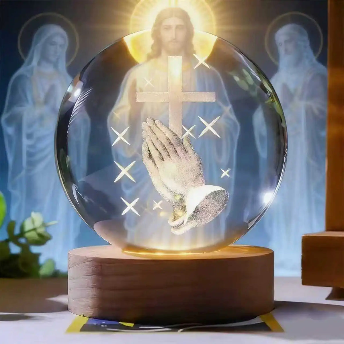 An illuminated crystal ball showing a figure of Jesus with outstretched hands and a cross, set on a wooden base.