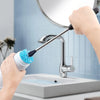 A hand is using a long-handled bottle brush set with stainless steel bristles to clean a kitchen faucet.