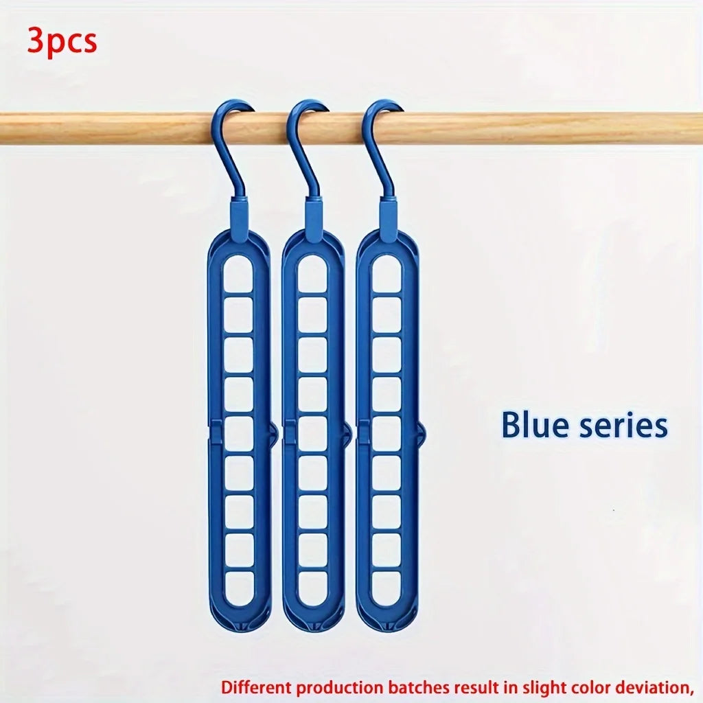 Three blue plastic foldable hangers hanging from a wooden rod.