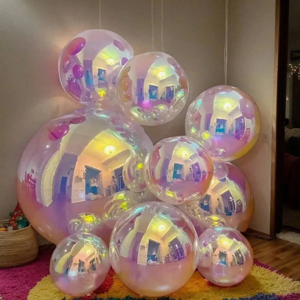 A collection of iridescent holographic foil balloons in various shades of pink and purple are displayed against a light backg