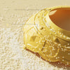 A yellow adjustable baby bath shampoo shield cap is shown with small white particles scattered around it.