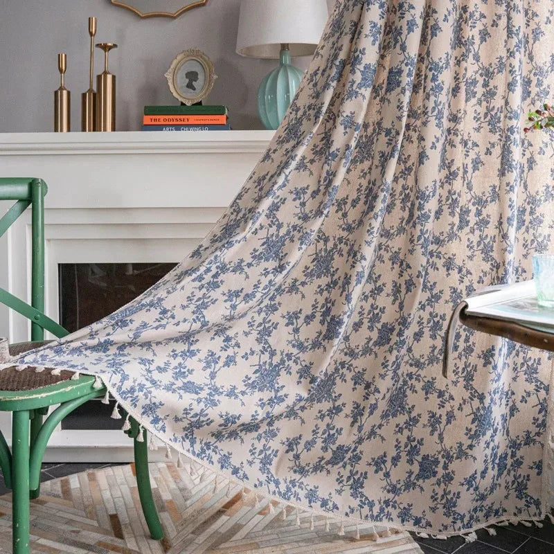 Leinenflorale Vorhänge in Beige- und Blauton, drapiert über einen weißen Kaminsims.