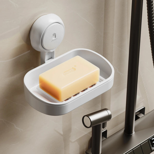 A white soap dish holder with a suction cup dispenser is mounted on a wall, holding a block of yellow soap.
