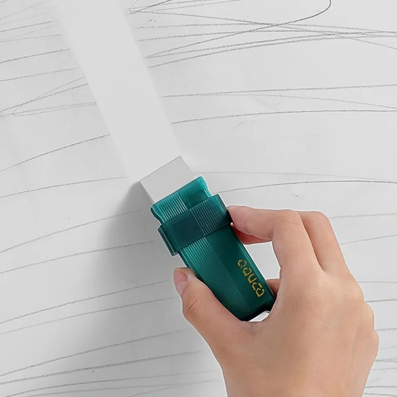 A hand holds a green reusable household stain remover eraser, demonstrating its size and texture.