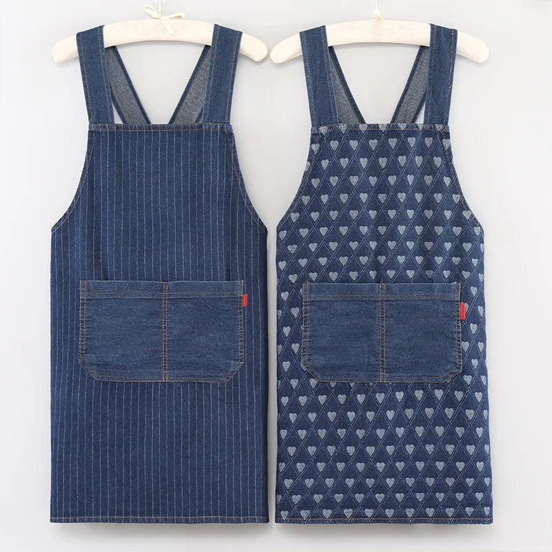 A pair of dark blue striped denim aprons hanging on a hanger.