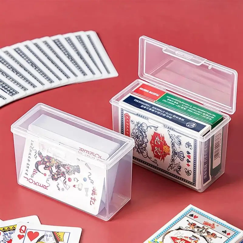 A clear plastic storage box is shown open, containing various cards and small items on a red background.