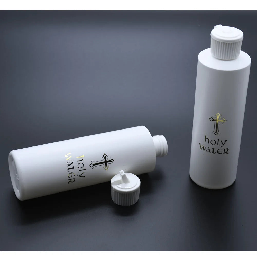 A white bottle of holy water with a white cap and a gold cross design, shown in a studio setting.